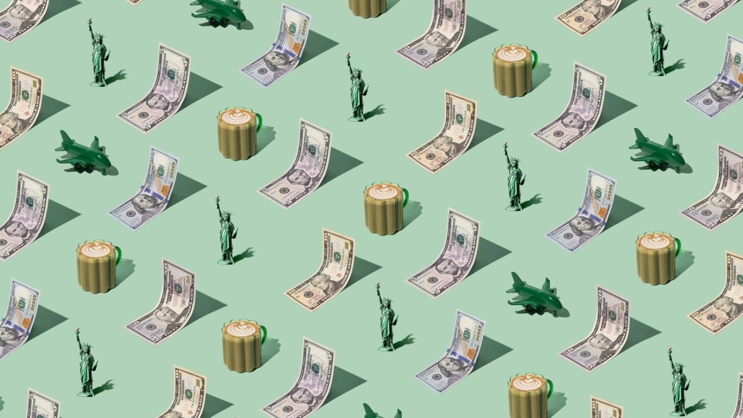 United States of America currency banknotes (US Dollars) laid out in a playful pattern with a Statue of Liberty figurine, coffee, and green plane for Travel Money Oz.