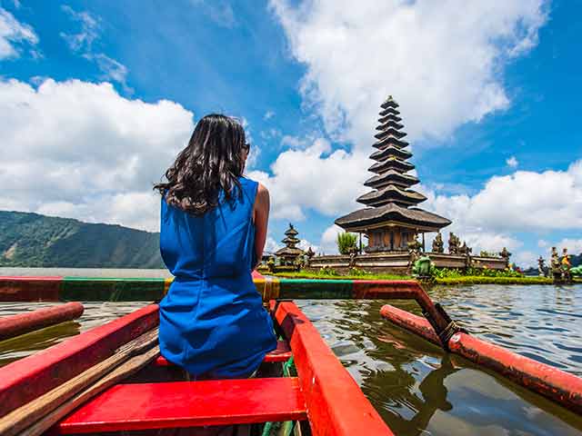 Lady in blue dress looking at temple in Bali 