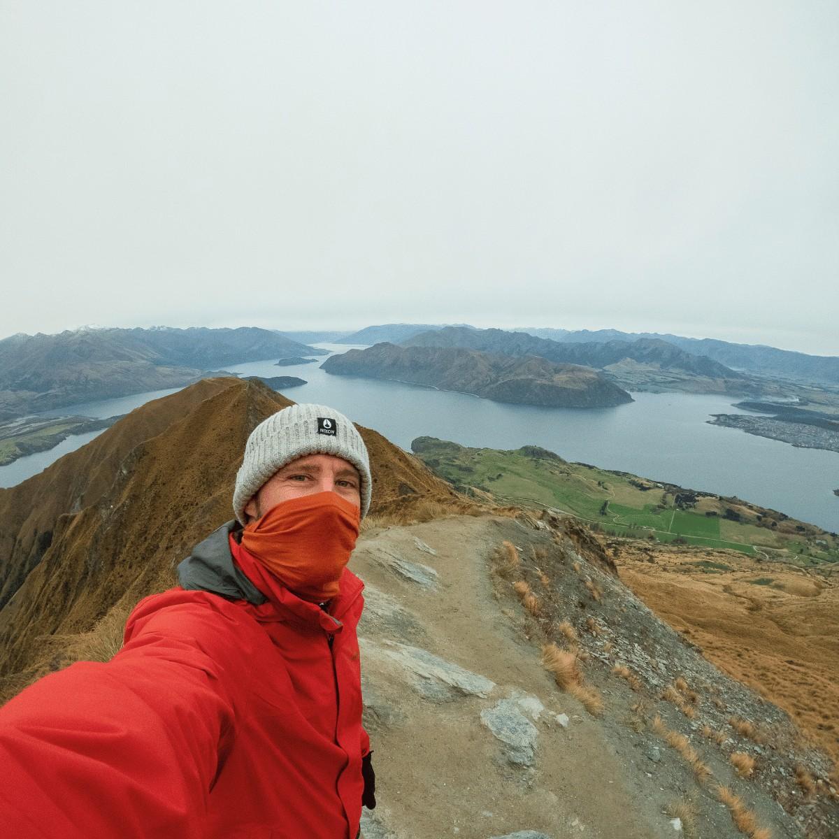 A traveller taking a selfie overlooking landscape in New Zealand