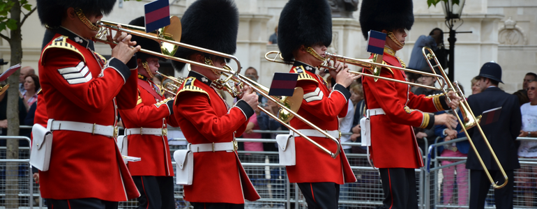 London guards playing trumpets outside Buckingham Palace London guards blowing trumpets outside Buckingham Palace during festivities.