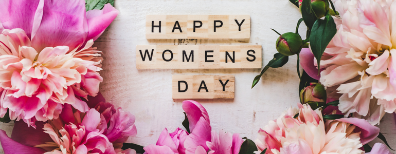 Flowers and wooden letters read International Women