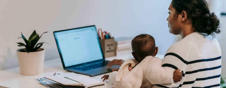 Mum working from home at the computer with her baby on her lap. Mother working from home at the computer with her baby on her lap.