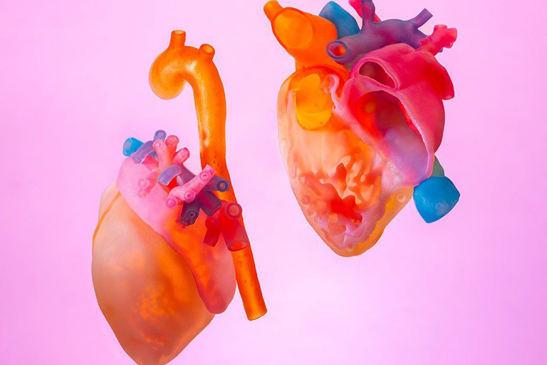 3d printed model of a heart, split into two pieces, floating in front of a pink background.