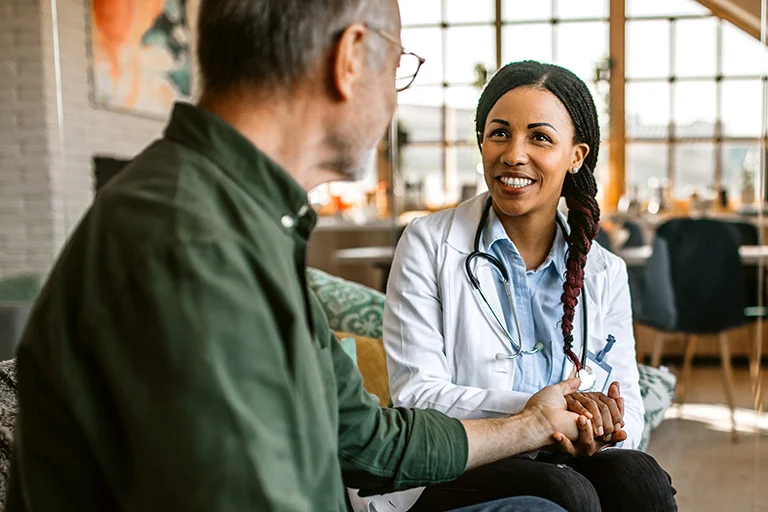 Smiling doctor talking to patient in office, in a modern clinic setting.