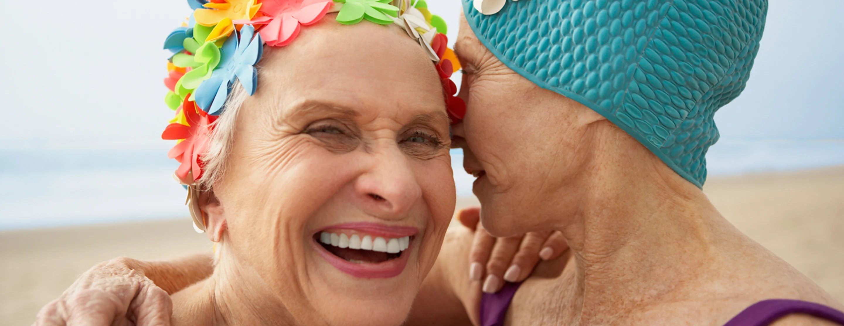 women smiling in swim caps