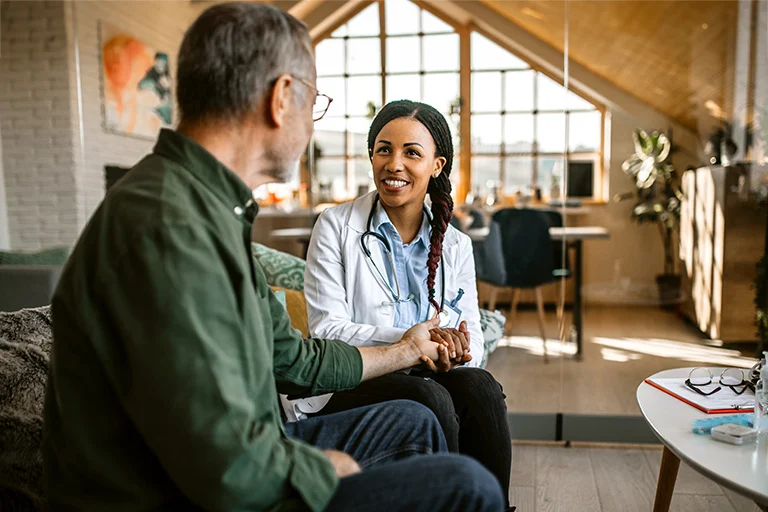 Smiling doctor talking to patient in office, in a modern clinic setting.