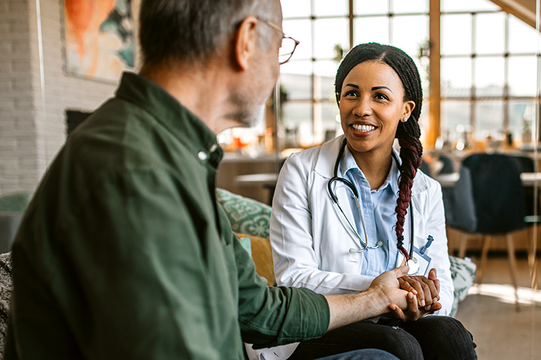 Smiling doctor talking to patient in office, in a modern clinic setting.