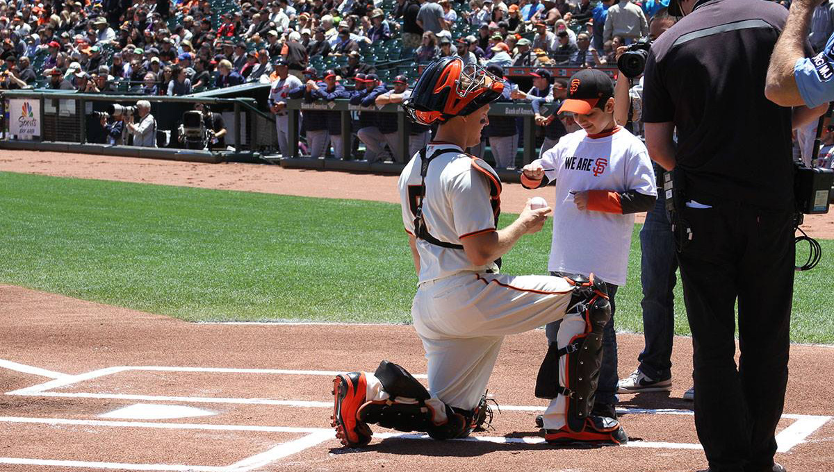 A baseball player and a kid in the field