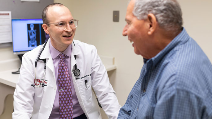 Oncologist Ben Derman, MD, meets with a patient in clinic