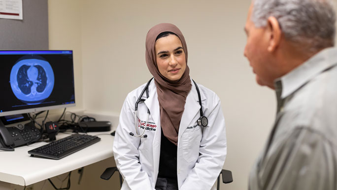 medical oncologist Mariam Nawas, MD, meets with a patient in clinic