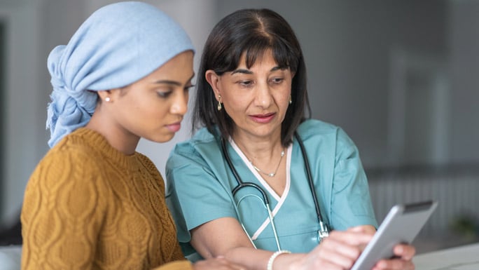 provider with patient, pointing to tablet