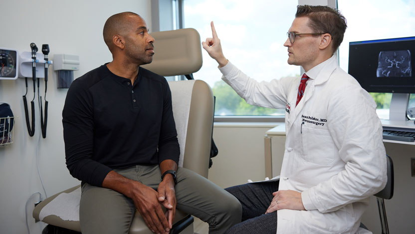  Neurosurgeon Sean Polster, MD with a patient. Dr. Polster specializes in minimally invasive surgery of the brain and spine