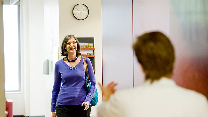 Woman greeted by staff member while walking from waiting room