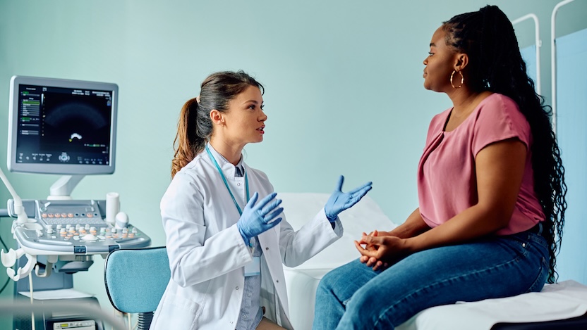 female doctor consulting female patient with ultrasound machine