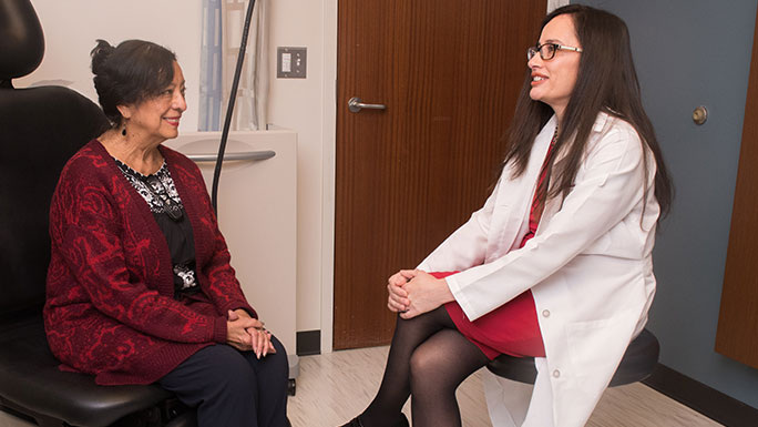 Gynecologic cancer risk and prevention specialist Iris Romero, MD, MS, consults with a patient