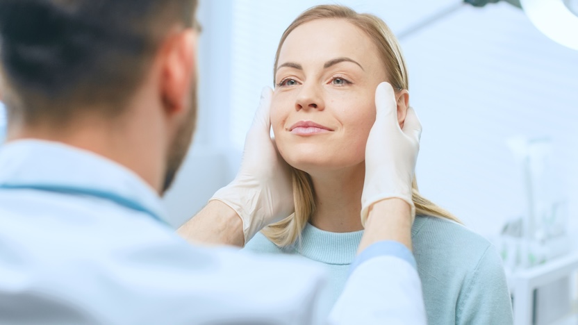 physician touching womens face