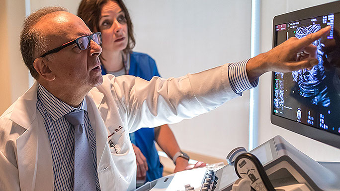 Fetal ultrasound expert Jacques Abramowicz, MD, and nurse reviewing an image on a screen