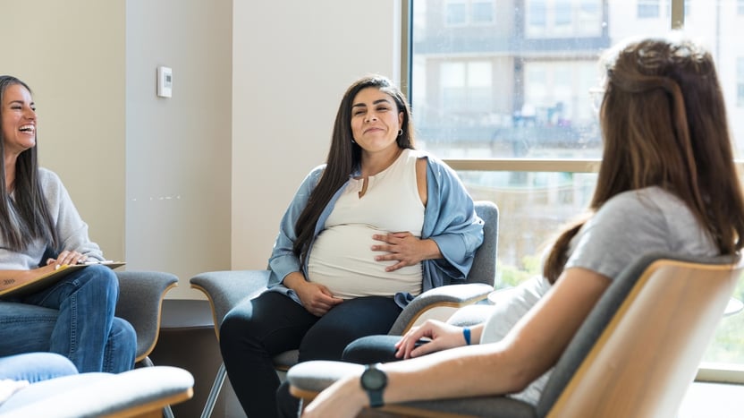 Mother holding baby speaking with specialist