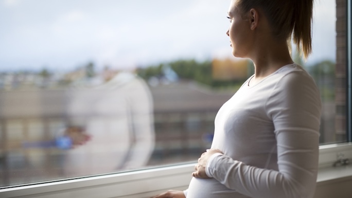 pregnant woman looking out a window