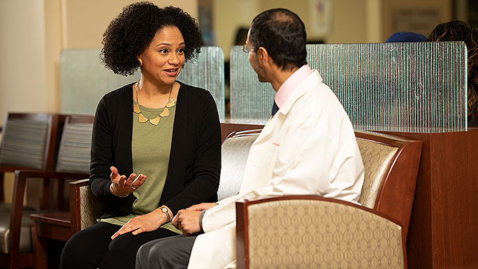 Reproductive endocrinologist Alberuni Zamah, MD, consulting with a patient