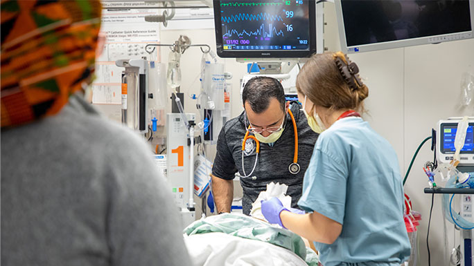 Physicians and residents provide care for a trauma patient