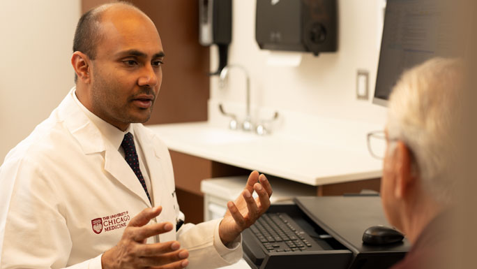Nishant Agrawal, MD, with a patient in clinic