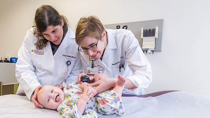 Pediatric dermatologists Dr. Adena Rosenblatt and Dr. Sarah Stein examine a giggling baby