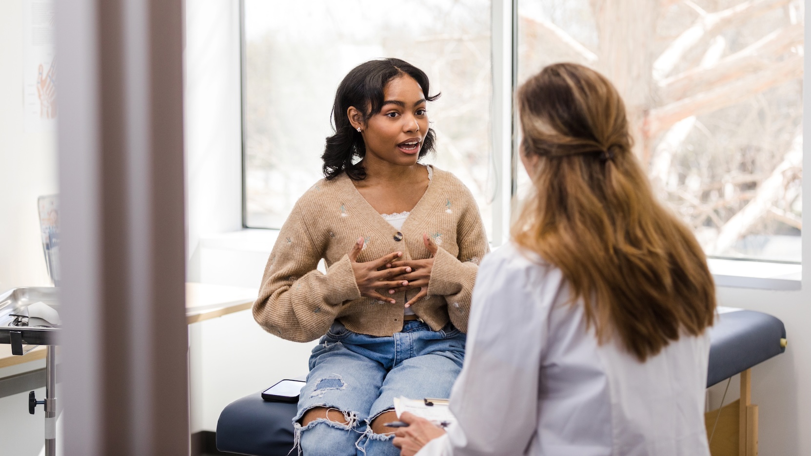 Teen girl speaking with female doctor