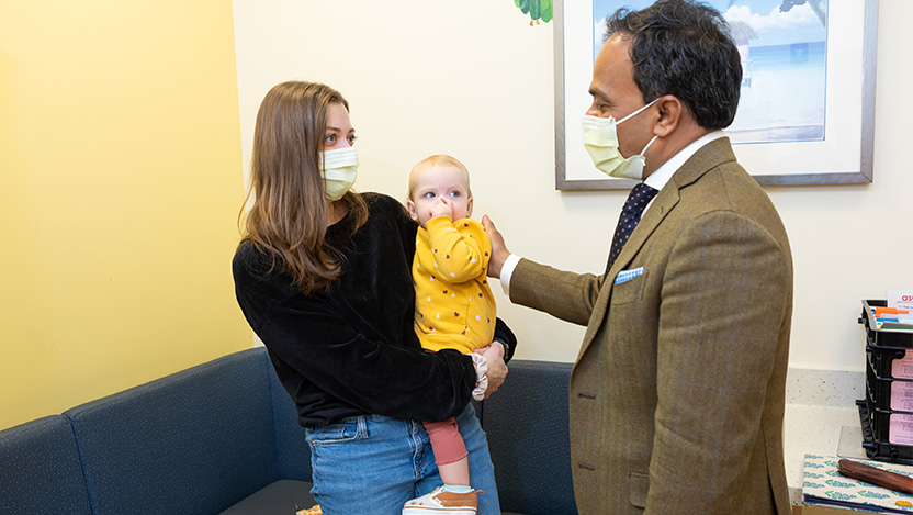Image of pediatric urologic surgeon Dr. Gundeti talking with a child and parent