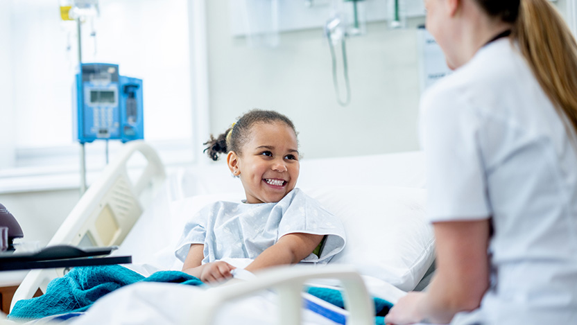 Image of pediatric general surgery patient smiling and laughing with a nurse