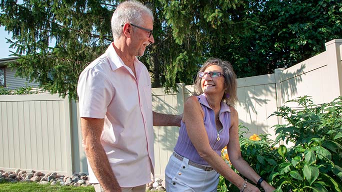 Man and woman take walk outside in garden