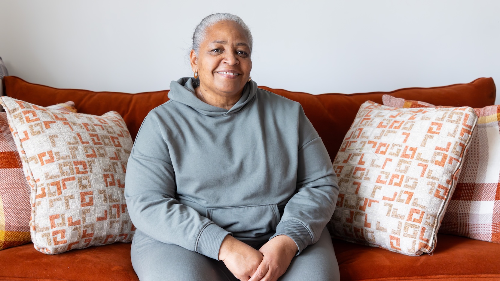 Sonya smiling on red couch