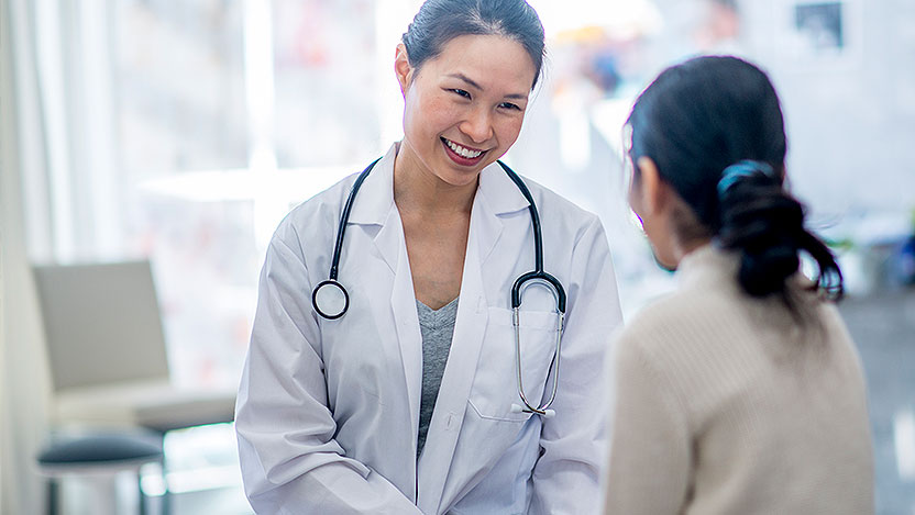 Doctor smiling at young patient during appointment