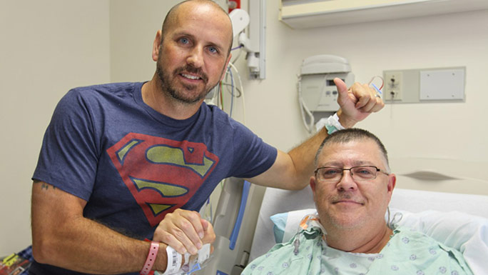 Kidney transplant patient Stewart Botsford (in bed) and his donor, Justin Maduena,