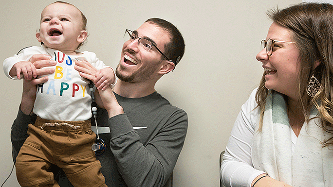 10-month-old Dennis Hill, post cochlear implant activation, with his dad, Michael Hill, and mom Jenna Jones