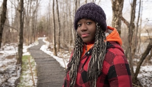 A woman is walking in the woods.