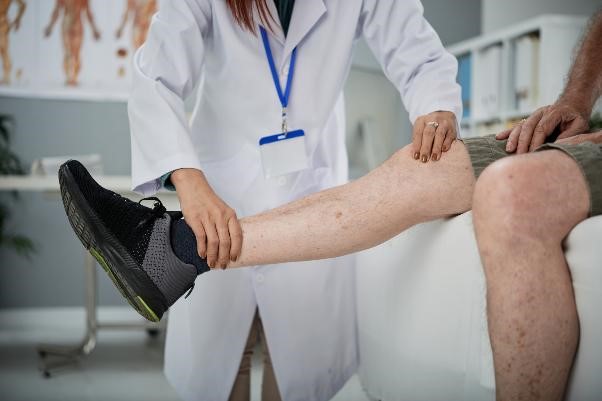A healthcare professional evaluating a patient's knee.