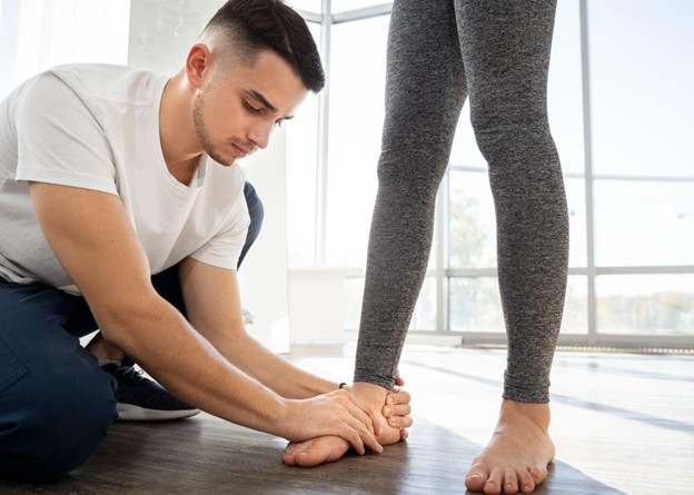 A trainer evaluating an athlete’s ankle during a sports injury assessment.
