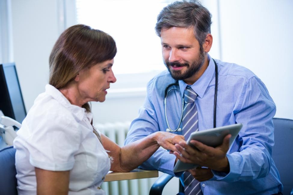 A physician discussing an individualized pain management treatment plan with an adult patient.
