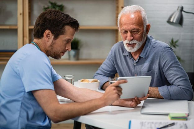A healthcare professional discussing outpatient surgical services with an adult patient.