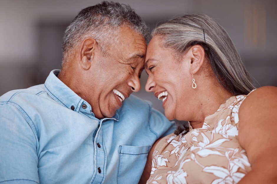 a happy senior couple smiling and touching heads