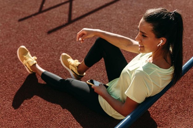 Teen athlete resting on a running track after an intense training session.