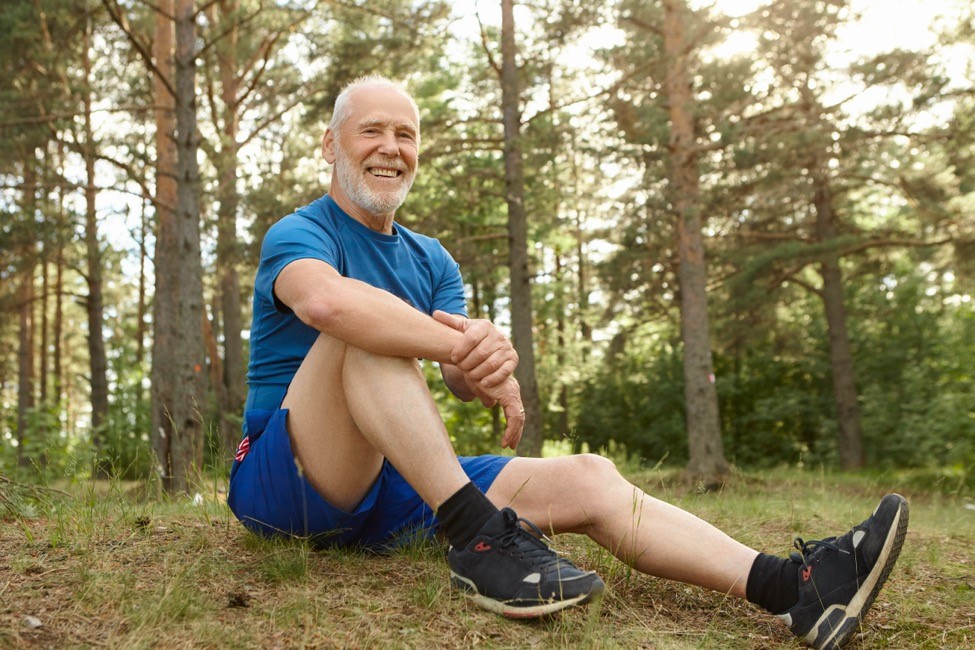 A healthy man takes a break from running outdoors. 