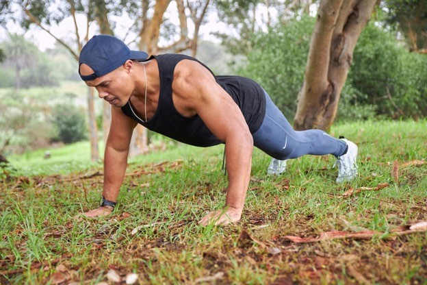 A healthy young man exercises outdoors.