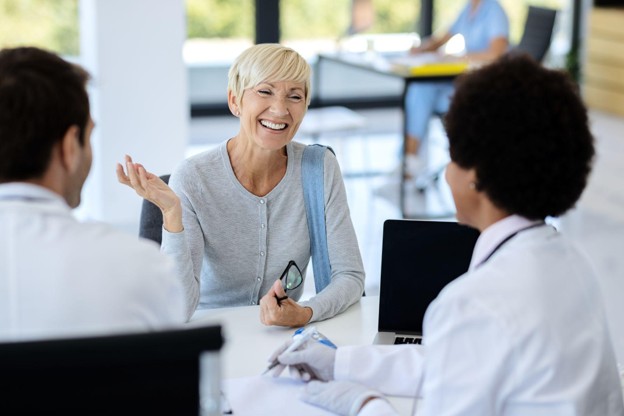 An adult patient discussing an outpatient surgical procedure with physicians during a preoperative consultation