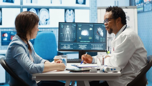 A physician reviewing diagnostic imaging and discussing treatment options with an adult patient