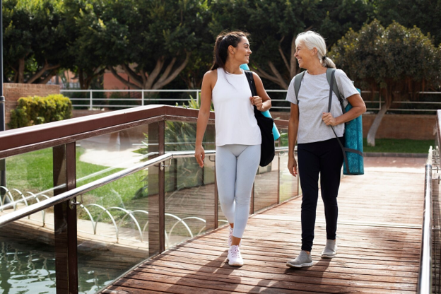 Two adults walking outdoors as one returns to normal daily activities after recovery from an outpatient surgical procedure