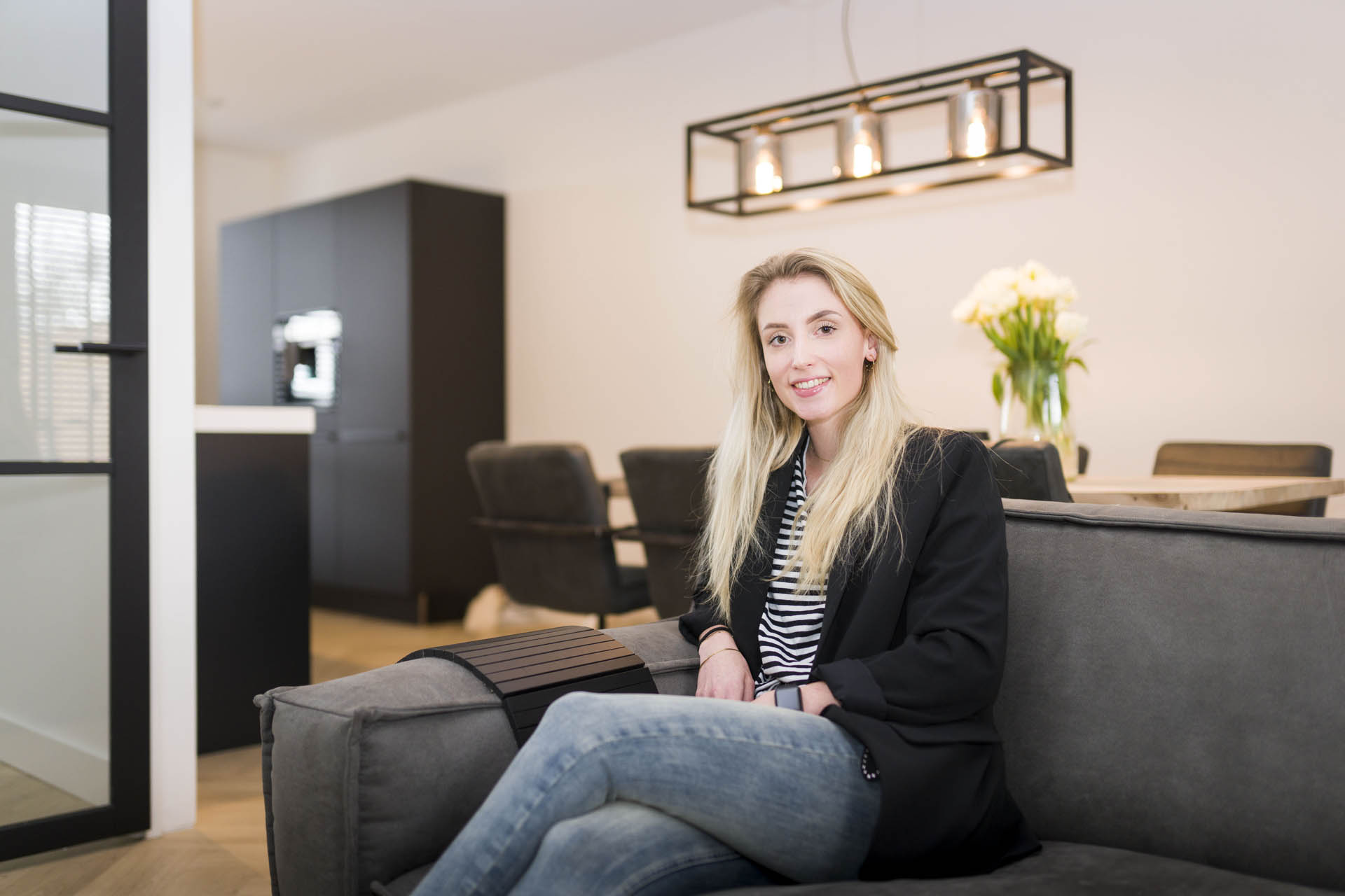 Bewoner Daniëlle op de bank in haar woning in Julianadorp