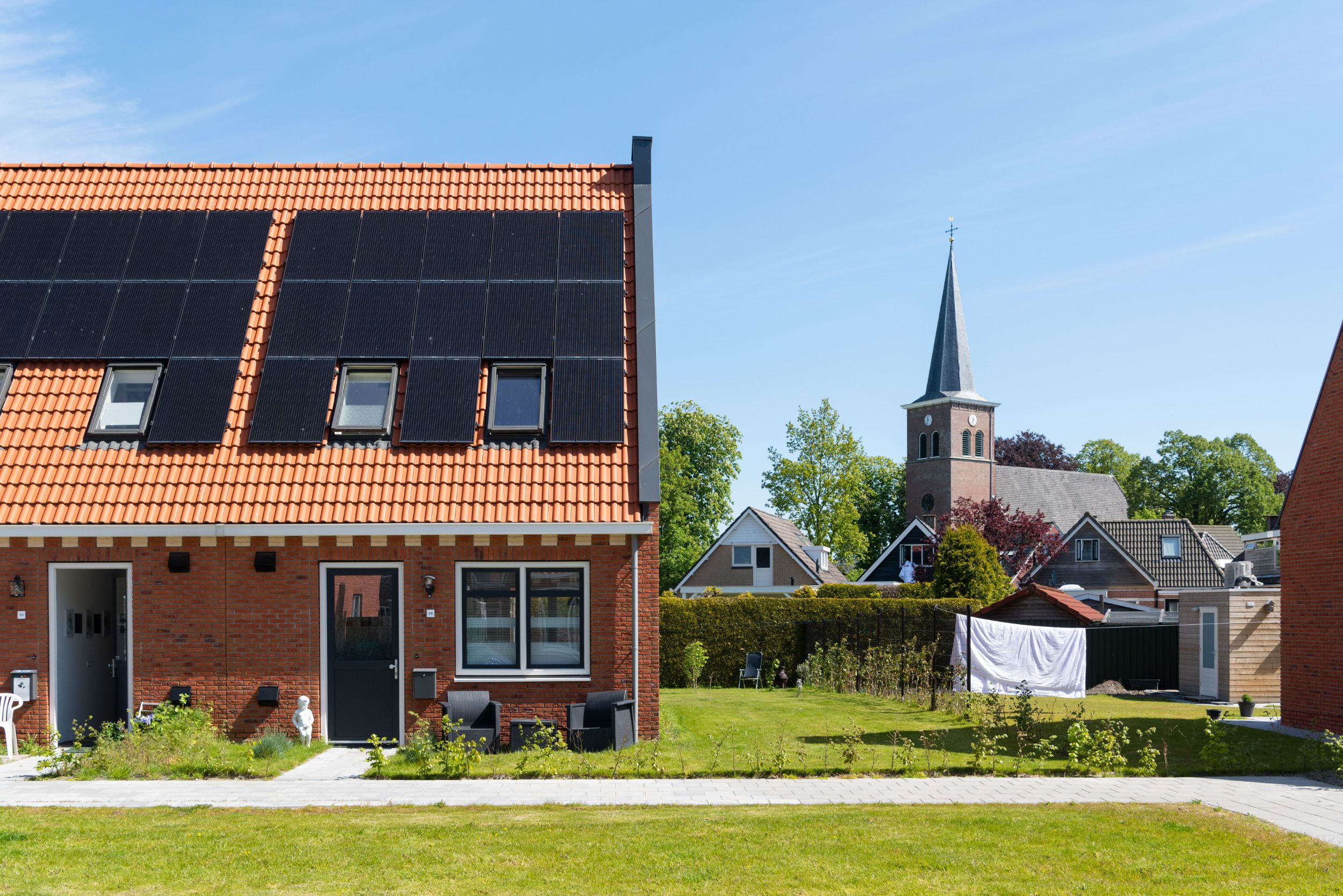 Foto van de woningen in Akkrum met een doorkijkje naar de kerk in het dorp