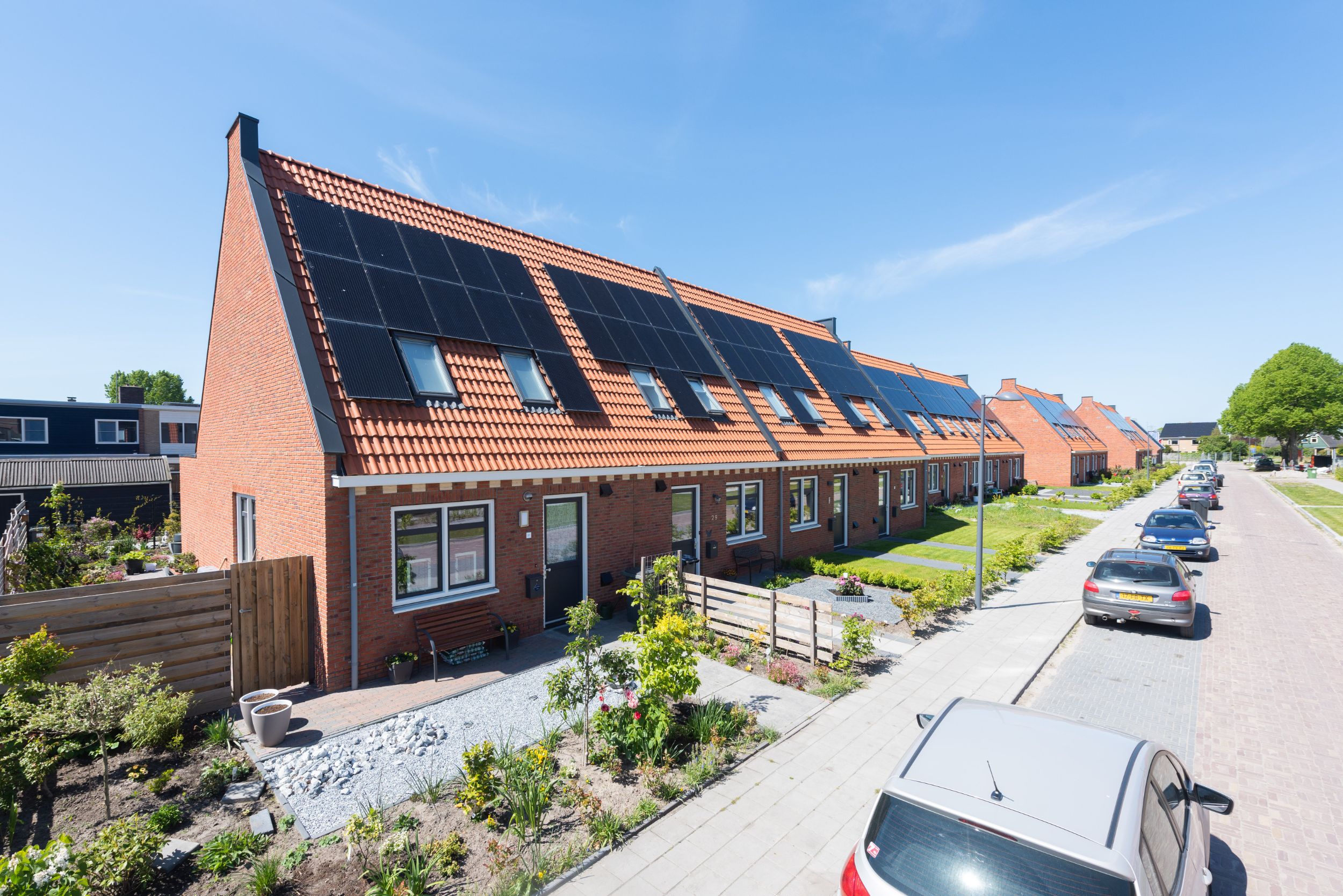 Foto van een rij woningen in Akkrum. Je ziet de voorkant van de woningen aan de straatkant.